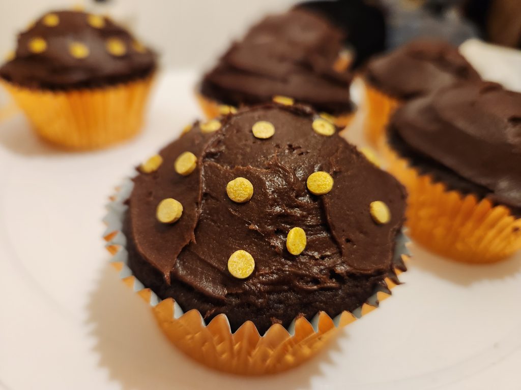 Chocolate cupcake with circular gold sprinkles