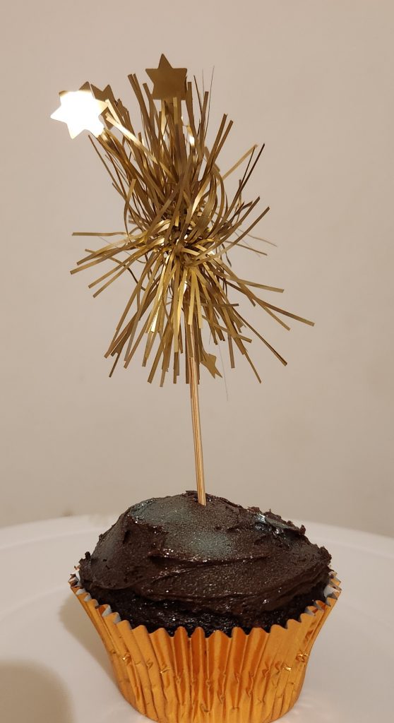 Chocolate cupcake with golden firework cupcake topper